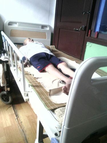 图二:洋口镇残联工作人员为白沙村瘫痪老人郑大森上门安装护理床