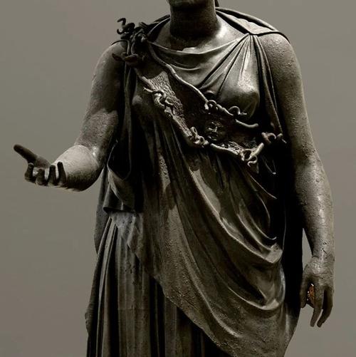 在这件女神雕像中,她头戴战盔,身着希腊式连衣长裙,护胸和甲胄上装饰