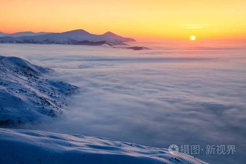 美妙的风景与高山在雪, 密集的纹理雾和日出在寒冷的冬天天.山在雾.